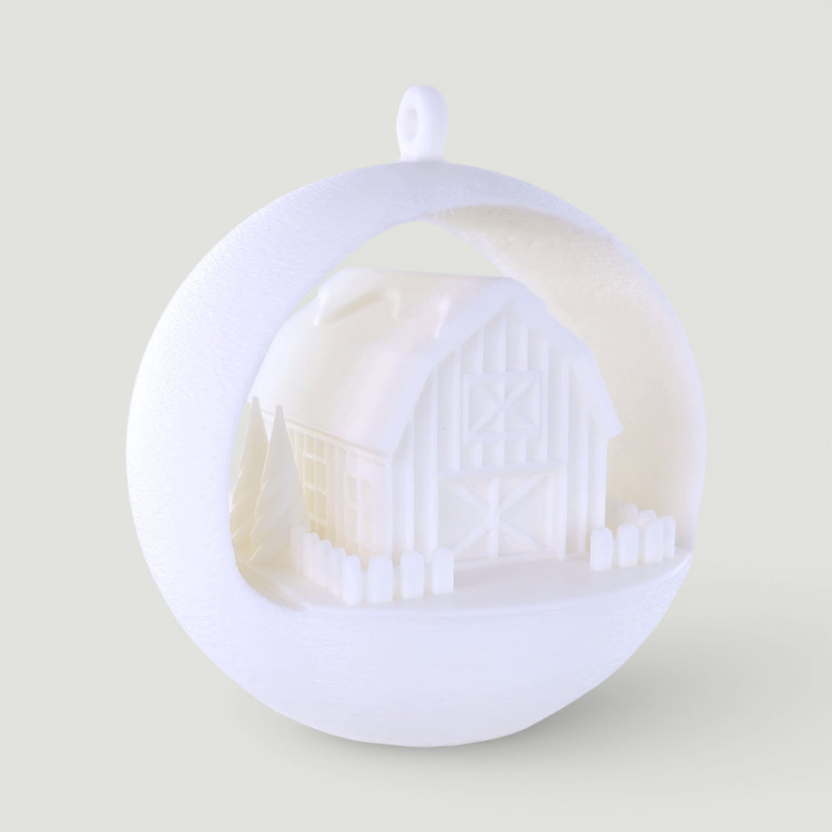 illuminated white barn ornament with miniature trees and picket fence, PLA plastic, rustic winter scene. Light off, rear left corner of ornament.