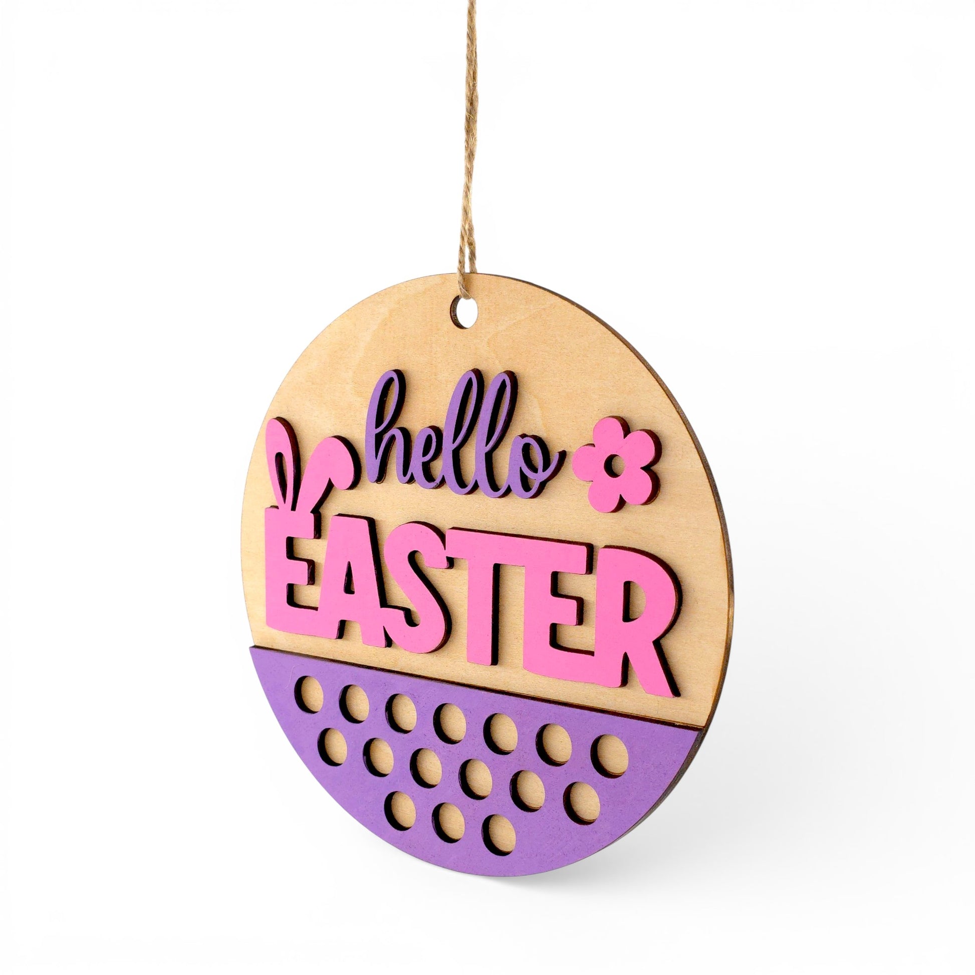 Round wood Easter sign with pink and purple "hello EASTER" text, bunny ears, and floral accent. Front left view of sign.