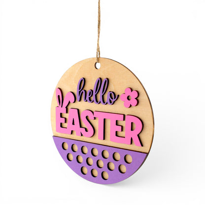 Round wood Easter sign with pink and purple "hello EASTER" text, bunny ears, and floral accent. Front left view of sign.