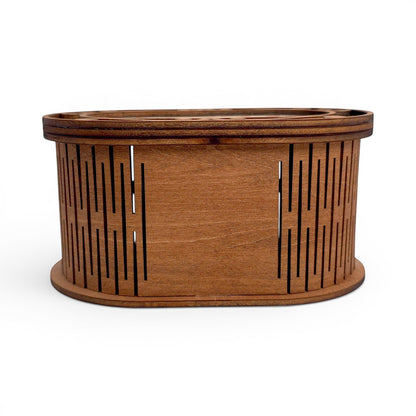 Oval wooden keepsake box with laser-cut slatted sides and a natural wood finish. Front side view of box, showing open slats.