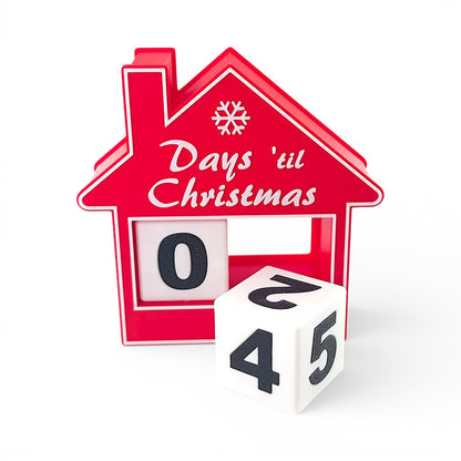 red house-shaped Christmas countdown advent calendar with rotating number blocks on a white base. front of house with one block inside the house and one black outside.