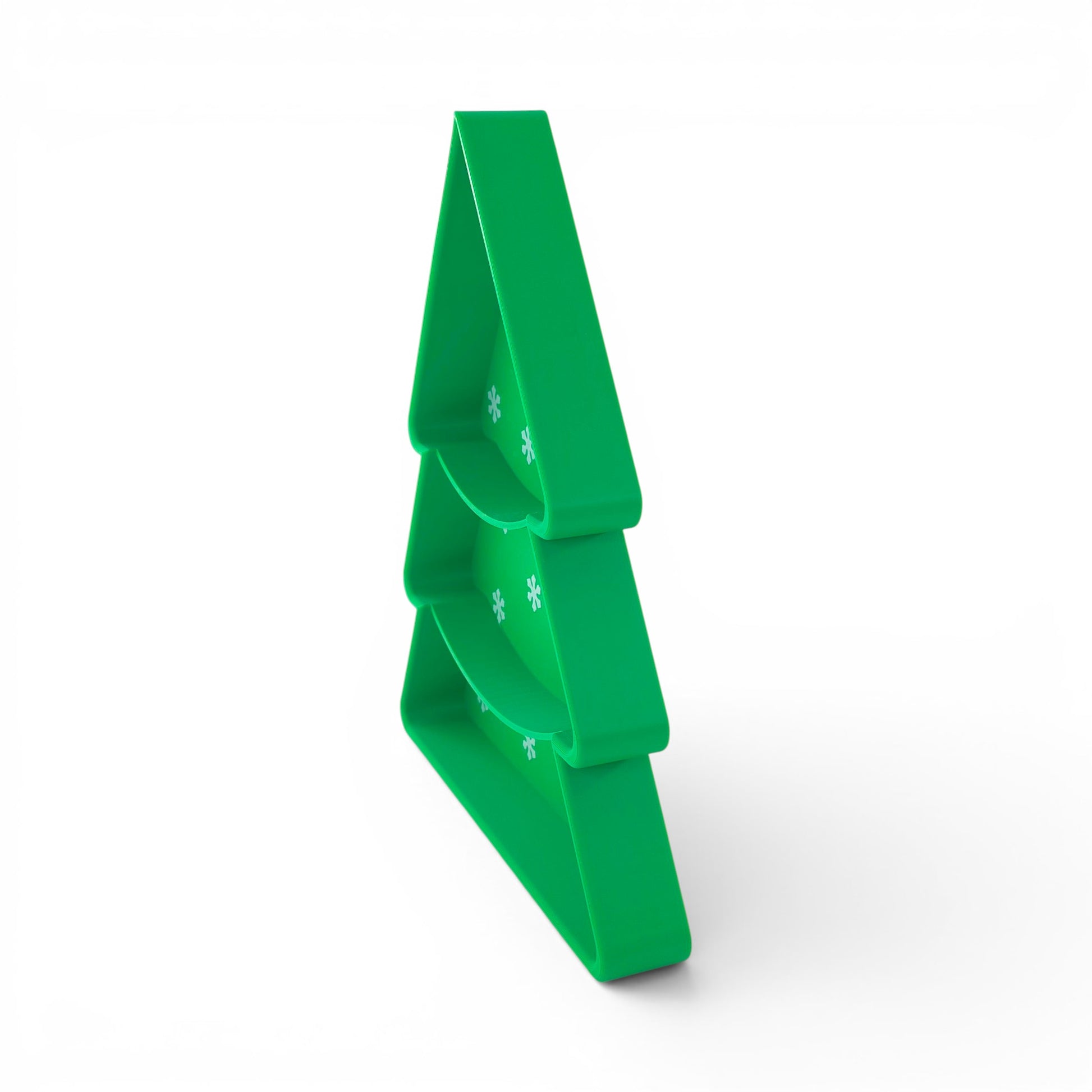 Green Christmas tree candy serving tray with tiered compartments and snowflake pattern. Upright side view of tray.