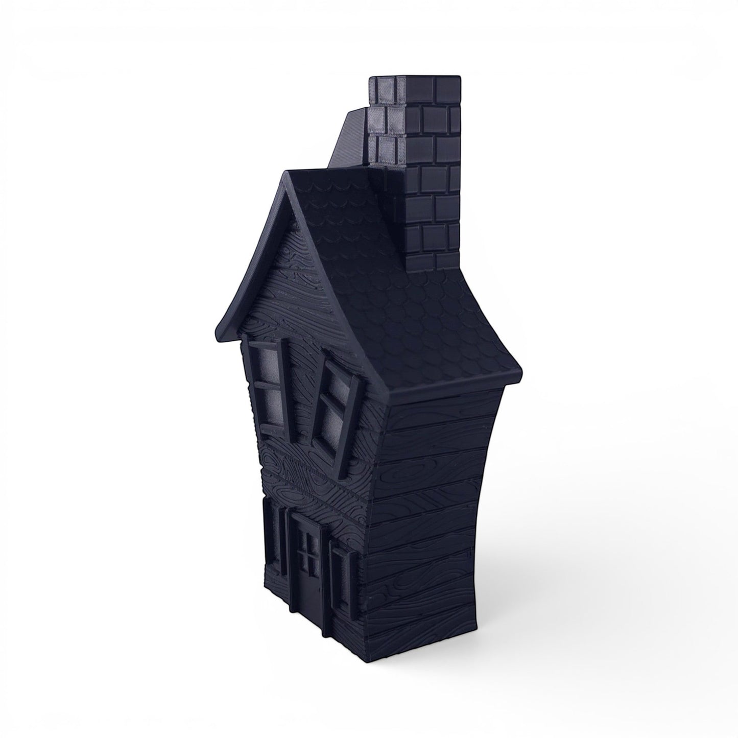 Black PLA haunted house decoration with textured wood finish, pitched roof, and chimney. Front right corner of house.