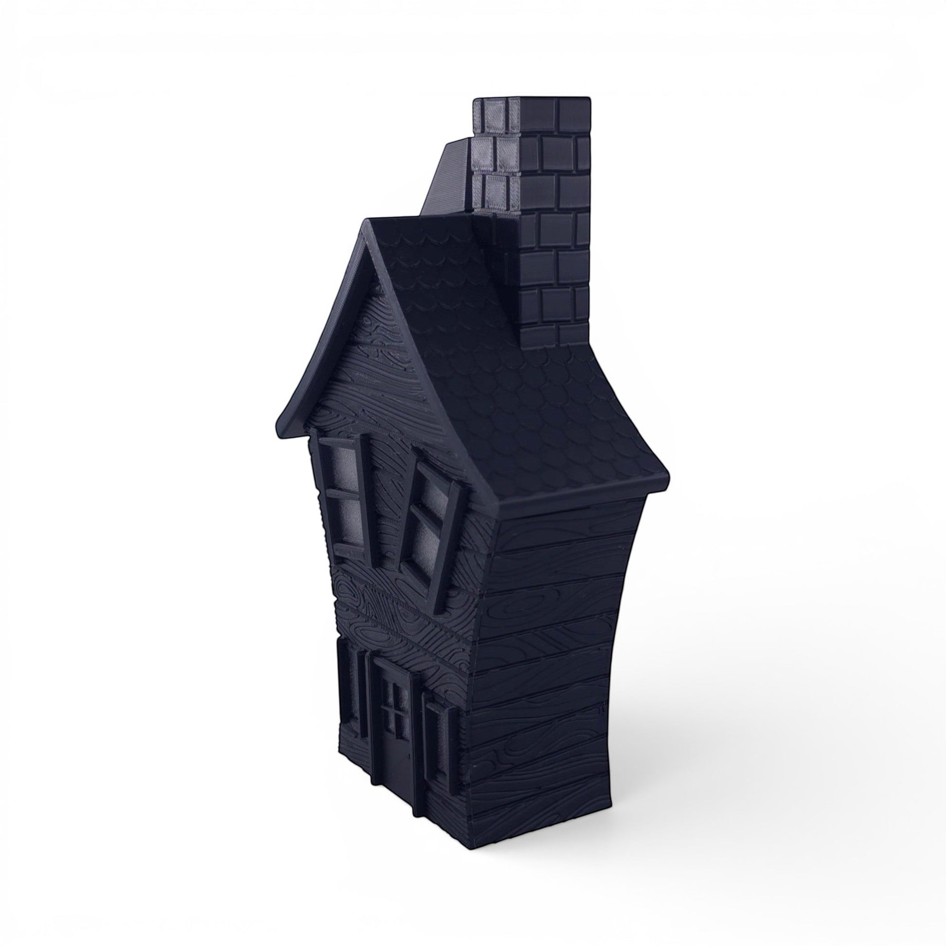 Black PLA haunted house decoration with textured wood finish, pitched roof, and chimney. Front right corner of house.