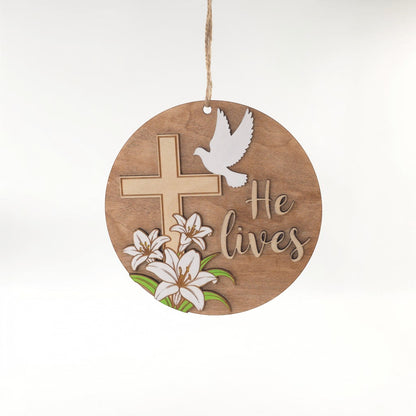 He Lives Easter wooden ornament with cross, lilies, and dove.