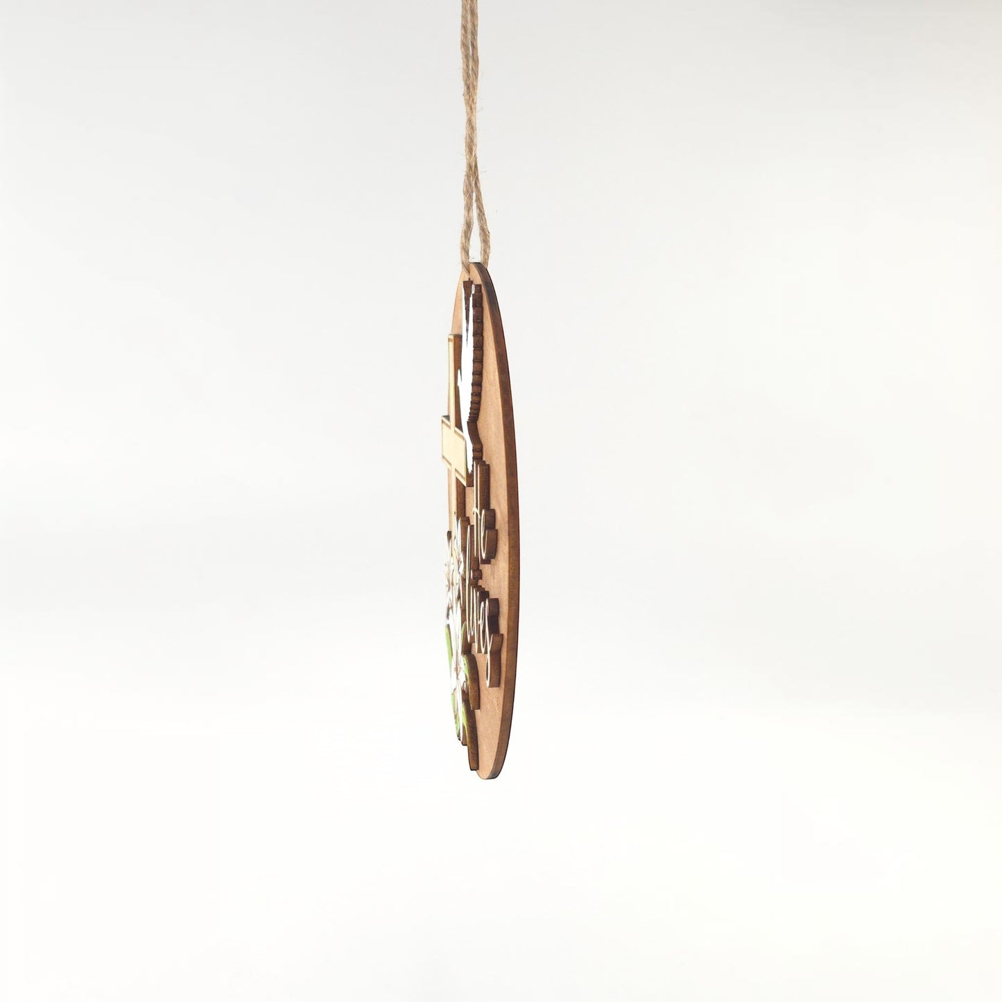 He Lives Easter wooden ornament with cross, lilies, and dove. Natural wood finish.