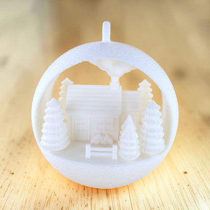 white PLA illuminated farmhouse ornament with evergreen trees and fence. Light off, front of ornament.