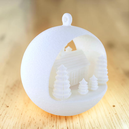 white PLA illuminated winter farmhouse ornament with evergreen trees and fence. Light off, back right of ornament.