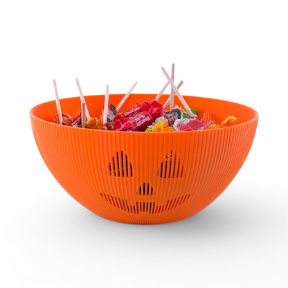 Orange PLA plastic Jack-o'-lantern candy bowl with carved face, filled with wrapped candies and lollipops. Front of bowl, filled.