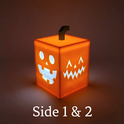 Jack O Lantern Cube Light with playful faces on each side, made of orange PLA, glows warm. Lighted.