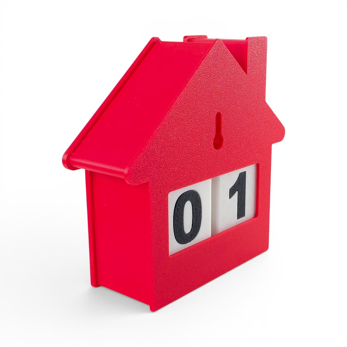 red house-shaped Christmas countdown advent calendar with rotating number blocks on a white base. Back right view of house with two blocks inside.