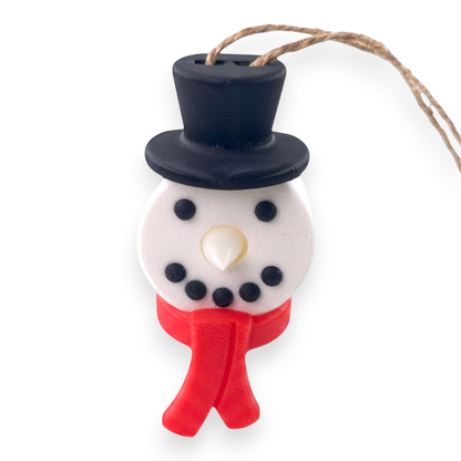 snowman tea light ornament with a black top hat, white face, and red scarf on a rustic twine loop