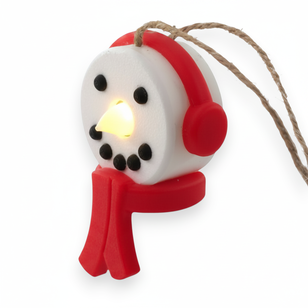 snowman tea light ornament with red headphones and scarf, glowing with a warm LED light