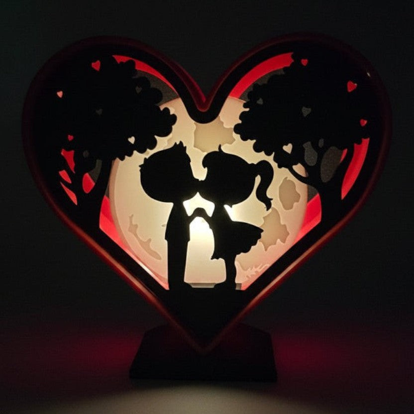 Valentines Heart Light Box with couple silhouette, trees, and moon. Red heart frame, soft LED light source behind the moon.