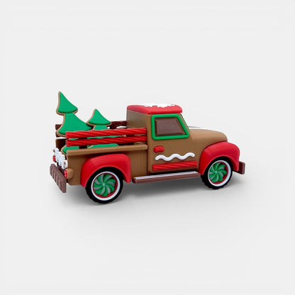 Vintage Christmas truck decoration with gingerbread accents, red wheels, and green trees.